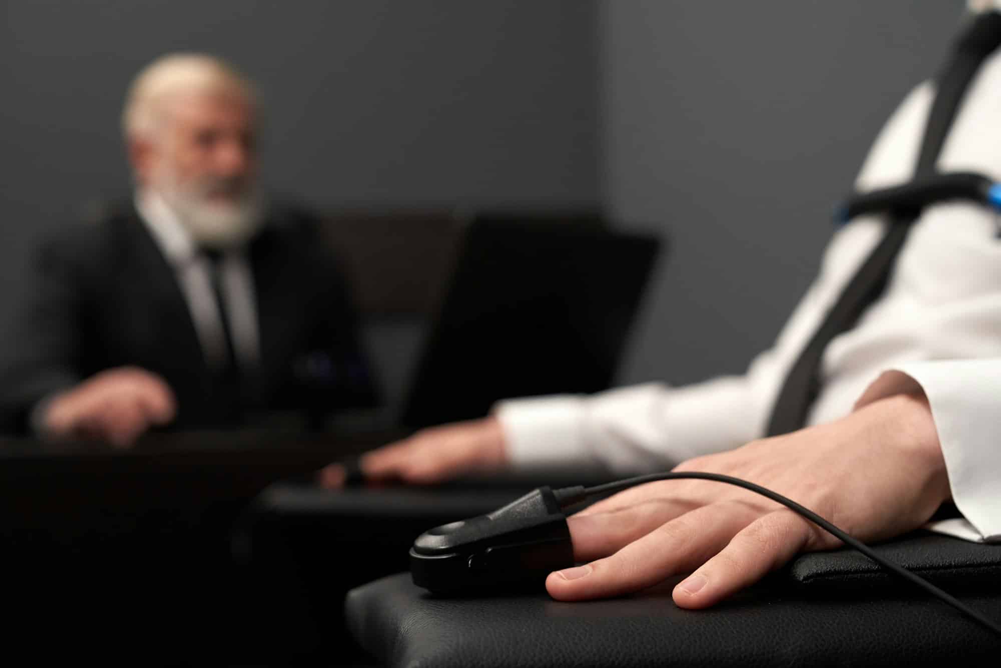 Closeup of pulse indicator on hand during lie detector test